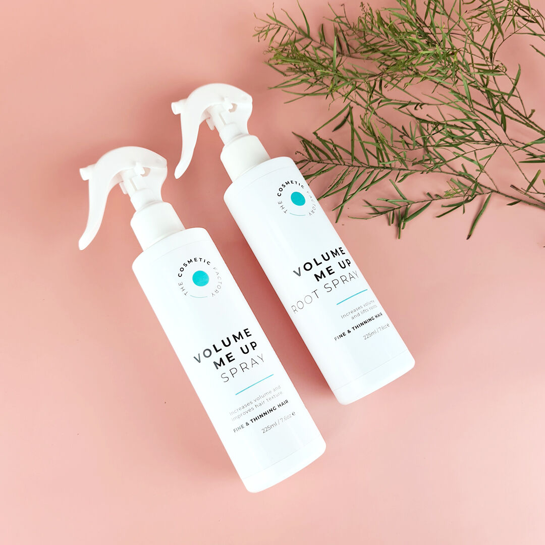 two bottles of ariel's sea salt spray 225ml on a table next to a branch.