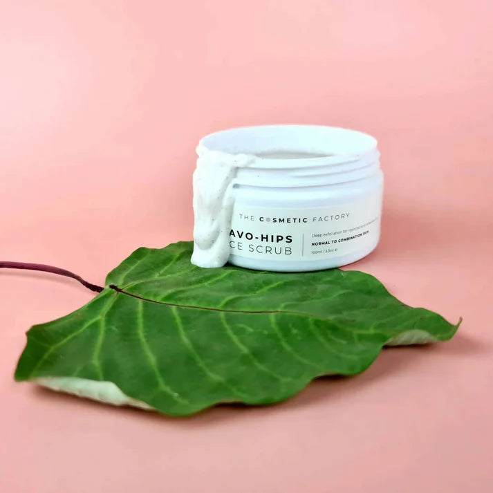 a jar of avo-hips face scrub 100ml on a green leaf.
