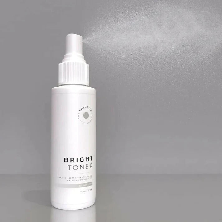a bottle of bright toner 120ml sitting on a table next to flowers.