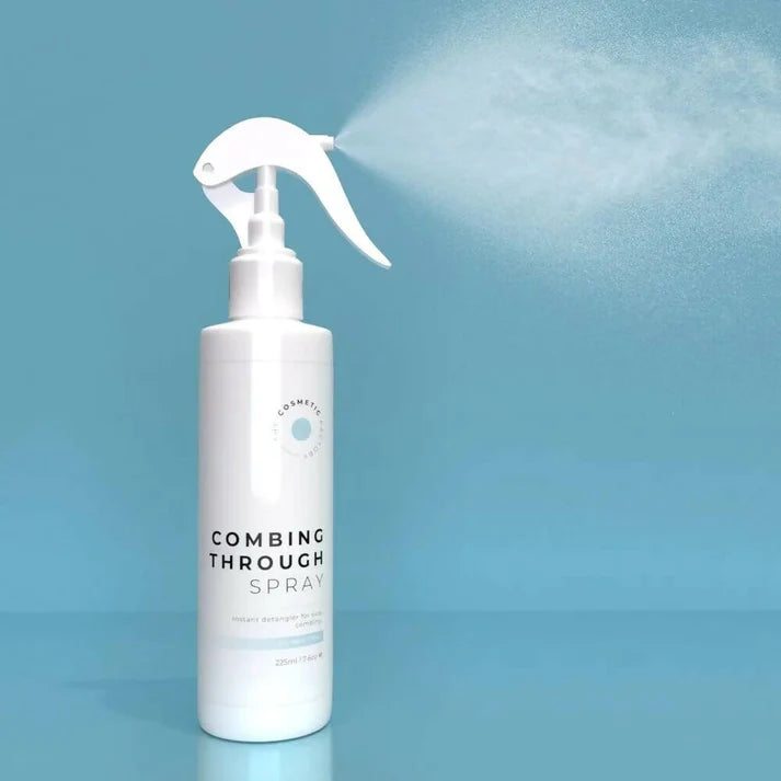 a bottle of combing through spray 225ml against a blue background.