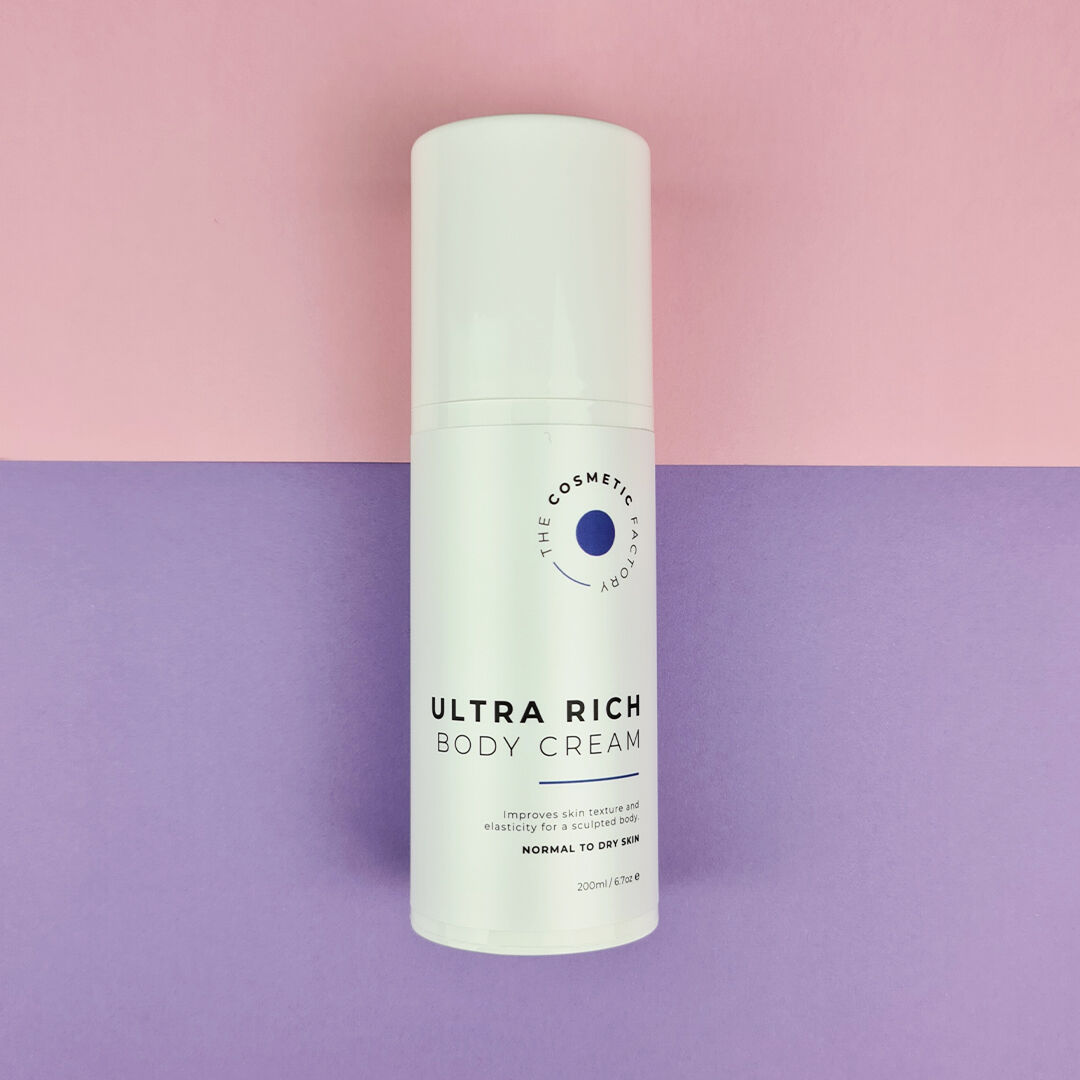 a bottle of ultra rich body cream 200ml on a blue surface.
